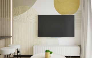 Nowoczesna ściana RTV z dekoracyjną geometryczną grafiką w odcieniach beżu, oliwkowej zieleni i musztardowej żółci, białą szafką RTV oraz minimalistycznym salonem.